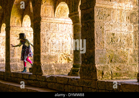 Europe, France, Var, Le Thoronet, abbaye cistercienne. Jeune fille jouant dans le le cloître. Banque D'Images