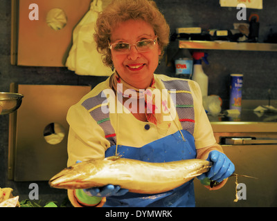 Vendeuse non identifiés tenant un poisson frais dans Mercat de Santa Caterina - Marché de produits frais à Barcelone, Catalogne, Espagne Banque D'Images