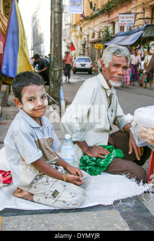 Un homme et son fils vendre des marchandises dans les rues de Yangon, Birmanie Banque D'Images