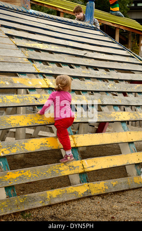 Baby Girl de ramper sur le mur à une aire striée Banque D'Images