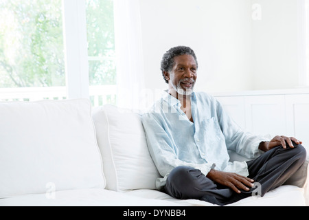 Senior man relaxing on sofa Banque D'Images