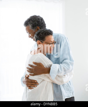 Senior couple hugging indoors Banque D'Images