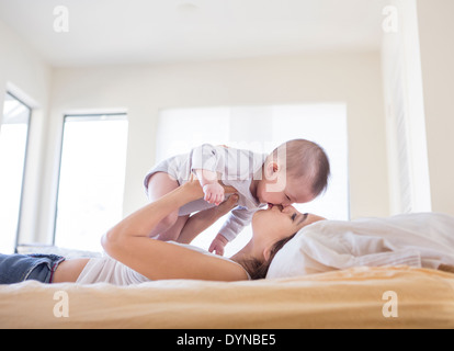 Mère jouant avec baby girl on bed Banque D'Images