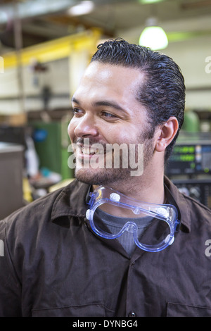 Hispanic worker smiling in warehouse Banque D'Images