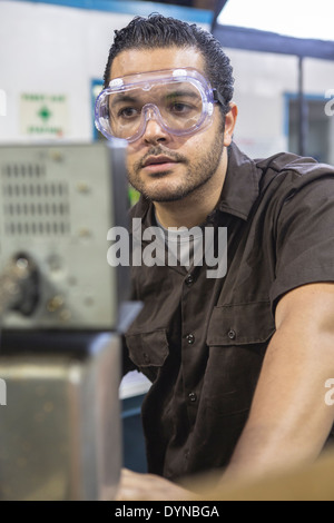 Travailleurs hispaniques de l'utilisation de machines en usine Banque D'Images