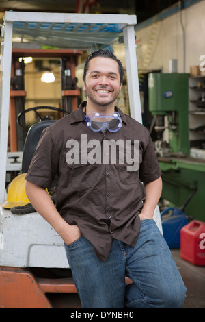 Hispanic worker smiling in warehouse Banque D'Images