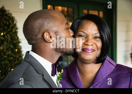 Groom kissing mère noire au mariage Banque D'Images