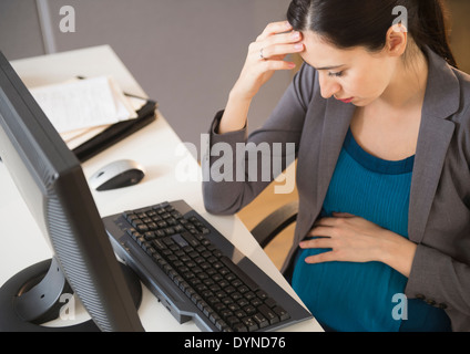 Femmes enceintes Caucasian businesswoman working in office Banque D'Images