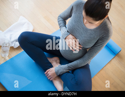 Pregnant Caucasian woman practicing yoga Banque D'Images