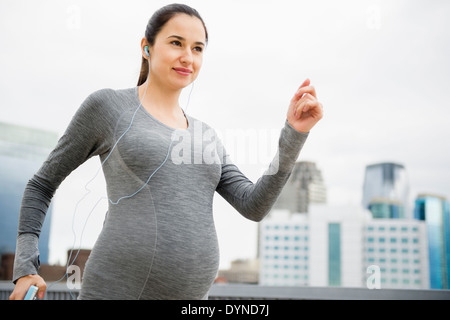 Femmes enceintes Caucasian woman jogging on city street Banque D'Images