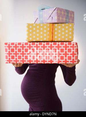 Pregnant Caucasian woman holding wrapped gifts Banque D'Images
