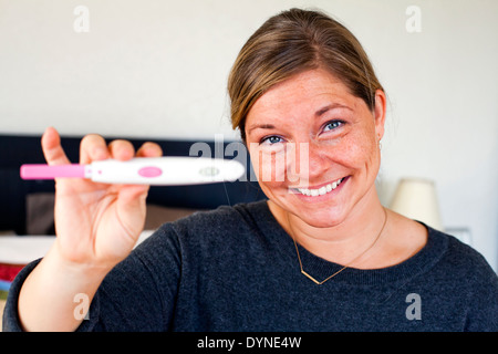 Caucasian woman holding test de grossesse positif Banque D'Images