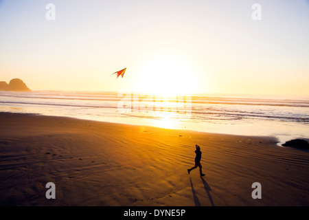 Caucasian woman flying kite on beach Banque D'Images