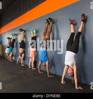 Des gens qui font des handstands ensemble dans une salle de sport Banque D'Images