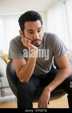 Mixed Race man resting chin in hand Banque D'Images