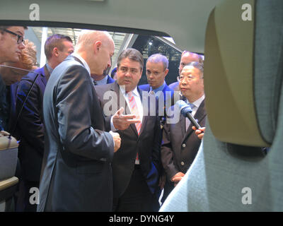Beijing, Chine. Apr 23, 2014. Chef de BMW en Chine, Karsten Engel (L) indique le ministre allemand des affaires économiques et de l'énergie Sigmar Gabriel (SPD), C) et vice-ministre chinois de l'industrie et de la technologie de l'information, Su Bo (R) La voiture électrique i3 lors d'une tournée à travers l'exposition automobile internationale de Beijing 2014 à Beijing, Chine, 23 avril 2014. Photo : TIM BRAUNE/dpa/Alamy Live News Banque D'Images