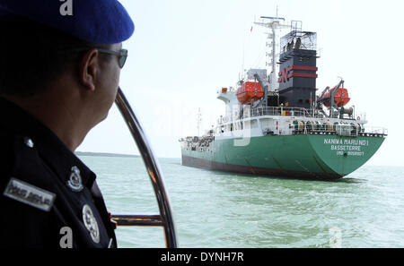 Port Klang, Malaisie. Apr 23, 2014. Un policier regarde le navire japonais volé à Port Klang, Malaisie, le 23 avril 2014. Un navire japonais a volé deux millions de litres de diesel par cinq hommes environ 16 milles marins de Pulau Ketam, une petite île au large de Port Klang, Malaisie, avec trois de ses 18 membres d'équipage a aussi enlevé par les brigands sur le chemin de Singapour à Myanmar, les médias locaux ont rapporté mercredi. Source : Xinhua/Alamy Live News Banque D'Images