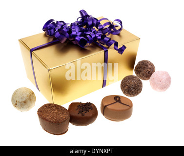 Une découpe D'OR FORT D'UN ASSORTIMENT DE CHOCOLATS À LA TRUFFE avec le joli ruban violet Banque D'Images