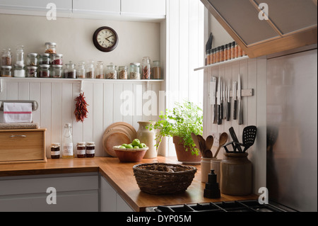 Des rayonnages ouverts et les surfaces de travail en chêne massif en cuisine avec des panneaux muraux en bois blanc Banque D'Images