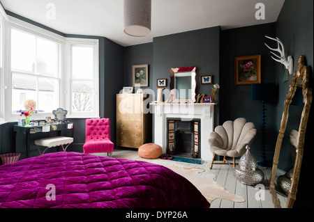 Peint foncé chambre avec un assortiment de boissons et de Graham et meubles vert. Une courtepointe pourpre est sur le lit Banque D'Images