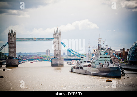 Tower Bridge et HMS Belfast, le navire s'est transformé en un musée, vu depuis le pont de Londres sur un matin d'été orageux. Banque D'Images