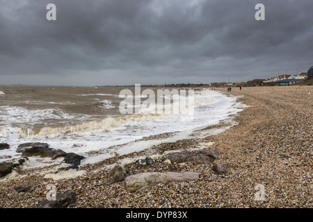 L'état de la mer et des vagues se brisant sur la plage de galets gris foncé sous ciel nuageux dans le mauvais temps orageux à Lee le Solent, Hampshire, Royaume-Uni Banque D'Images