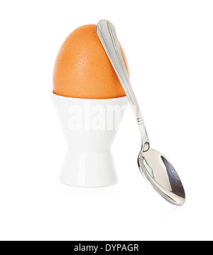 Brown egg bouilli dans la tasse, sur un stand avec une cuillère isolated on white Banque D'Images