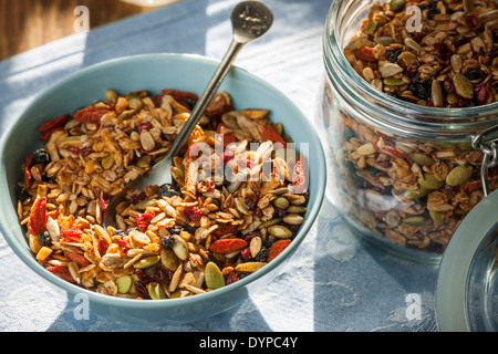 Servant de granola maison sur table avec linge de lit dans la lumière du soleil du matin Banque D'Images