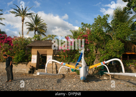 Un bateau repose sur la plage de sable d'Amed, un village de pêcheurs à l'Est de Bali. Amed est une longue bande côtière de villages de pêche en E Banque D'Images