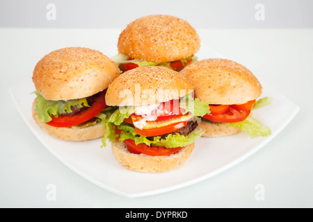 Gros hamburgers faits maison déposer sur plaque blanche. Studio photo Banque D'Images