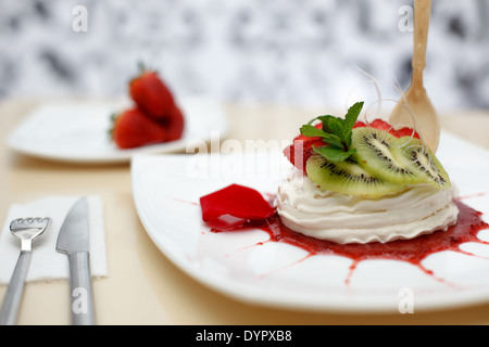 La crème fouettée dans la glace en verre avec fraise et kiwi Banque D'Images