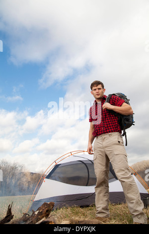 Randonneur met en place le camp avec tentes et feu de camp Banque D'Images