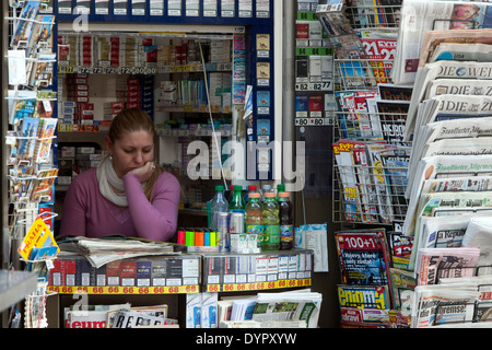 Vendeuse dans un kiosque à journaux avec magazines du monde et journaux stand Prague Banque D'Images