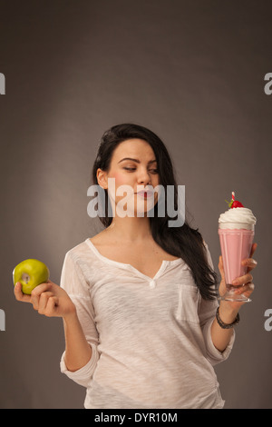 Caucasian girl avec milk shake et apple, faire des choix santé Banque D'Images