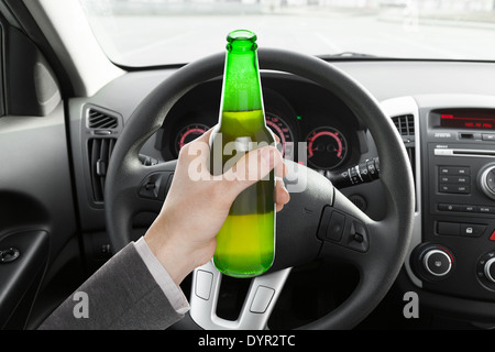 Male hand holding bouteille de bière en driving car Banque D'Images