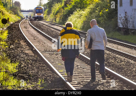 Lurgan, Irlande du Nord. 24 mars 2014 - Deux enquêteurs judiciaires à pied le long d'une voie ferrée à l'endroit où une personne a été tué après avoir été frappé par un train Crédit : Stephen Barnes/Alamy Live News Banque D'Images