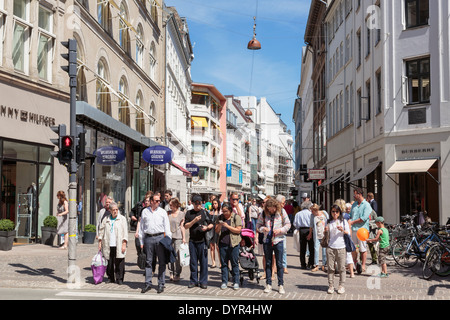 Scène de rue animée avec des gens qui attendent pour traverser une route sur l'une des plus longues rues piétonnes. Strøget Copenhagen Danemark Banque D'Images