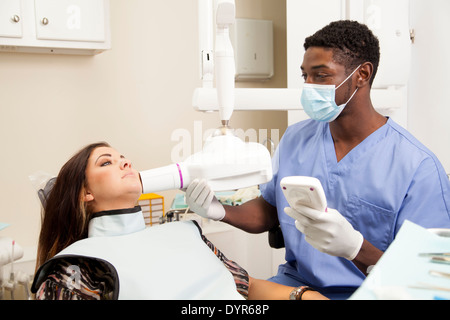 African American male tech dentaire en prenant un oral x ray on female patient Banque D'Images