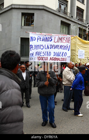 Un enseignant à la retraite porte une bannière lors d'une marche de protestation exigeant une augmentation des paiements de pension du gouvernement pour les enseignants, la Paz, Bolivie Banque D'Images