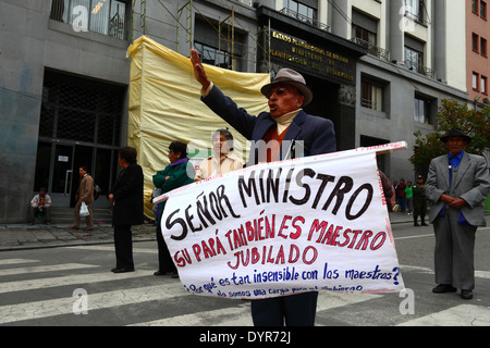 Un enseignant à la retraite porte une bannière lors d'une marche de protestation exigeant une augmentation des paiements de pension du gouvernement pour les enseignants, la Paz, Bolivie Banque D'Images