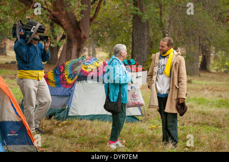 Femme portant des vêtements chauds pour jeune homme vivant dans une tente en parc urbain-Victoria, Colombie-Britannique, Canada. Banque D'Images