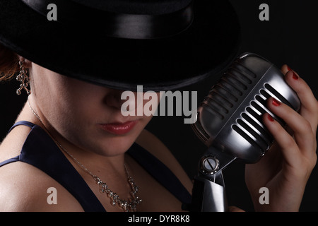 Beau chant jazz femme avec Fedora et retro style microphone Banque D'Images