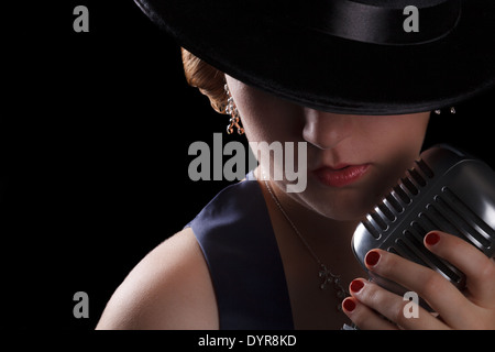 Beau chant jazz femme avec Fedora et retro style microphone Banque D'Images