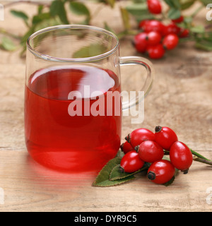 Thé de rose musquée dans un verre sur une table en bois Banque D'Images