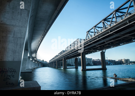 Un vieux pont du chemin de fer à côté d'un bâtiment moderne en béton l'un à Sydney Banque D'Images