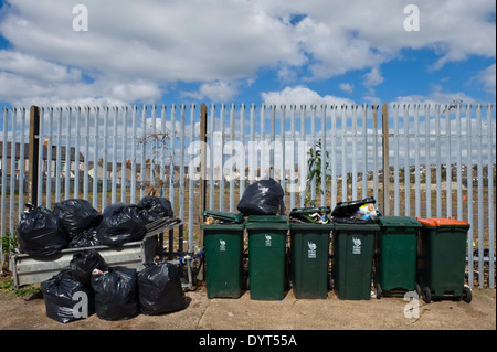 La wheelie bins contre clôture industrielle Newport South Wales UK Banque D'Images