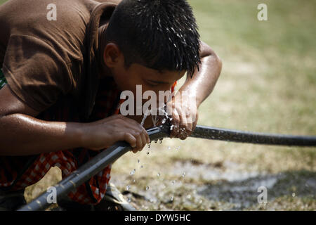 Dhaka, Bangladesh. Apr 25, 2014. Un garçon l'eau potable de la conduite d'eau tout en jouant sur le terrain.Les gens dans la capitale a connu la journée la plus chaude dans les 54 dernières années comme le mercure a grimpé à 40,7 degrés Celsius hier, le Met Office dit.La précédente la température la plus élevée a été enregistrée dans la capitale 42,3 degrés le 30 avril 1960, selon le Bangladesh Meteorological Department. La température la plus élevée le 24 avril l'année dernière à Dhaka a été 34,2 degrés. Zakir Hossain Chowdhury Crédit :/NurPhoto ZUMAPRESS.com/Alamy/Live News Banque D'Images