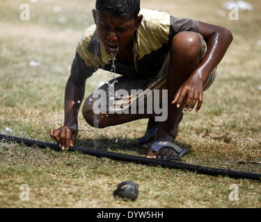 Dhaka, Bangladesh. Apr 25, 2014. Un garçon l'eau potable de la conduite d'eau tout en jouant sur le terrain.Les gens dans la capitale a connu la journée la plus chaude dans les 54 dernières années comme le mercure a grimpé à 40,7 degrés Celsius hier, le Met Office dit.La précédente la température la plus élevée a été enregistrée dans la capitale 42,3 degrés le 30 avril 1960, selon le Bangladesh Meteorological Department. La température la plus élevée le 24 avril l'année dernière à Dhaka a été 34,2 degrés. Zakir Hossain Chowdhury Crédit :/NurPhoto ZUMAPRESS.com/Alamy/Live News Banque D'Images