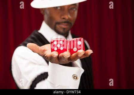 Joueur bien habillé dans un costume rétro tenant plus de dés de taille moyenne Banque D'Images