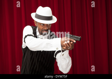 Joueur bien habillé dans un costume rétro braquer une arme Banque D'Images